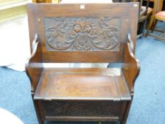 A SMALL POLISHED MONKS BENCH with carved lions mask lid and carved front to a box seat