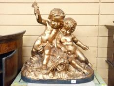 CHERUB GROUP in a hollow cast composition, one cherub holding a torch aloft