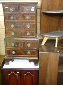 A REPRODUCTION CHEST ON CHEST having three long and two short drawers to the upper portion with