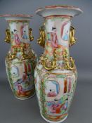A PAIR OF CANTON FAMILLE ROSE DECORATED VASES, late 19th Century with gilt salamanders in relief and