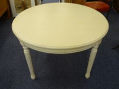 A CIRCULAR LIGHTWOOD EXTENDING DINING TABLE, 75cms height, 120cms diameter closed