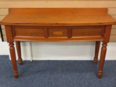 A PINE CONSOLE TABLE with rail back and bow front, 135cms width, 43cms depth