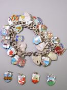 A SILVER CHARM BRACELET with padlock clasp holding in excess of forty mainly silver and enamel place