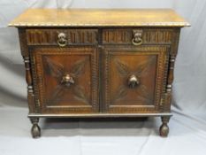A CONTINENTAL OAK SIDEBOARD with carved head and lion mask handles, having pillared sides on