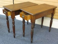 A PAIR OF ANTIQUE PINE HALL TYPE TABLES on turned supports and drawers at both ends, 84cms