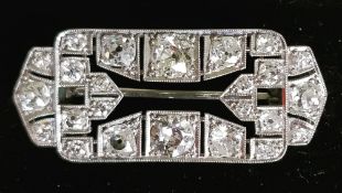 AN ART DECO DIAMOND BROOCH with open centre surrounded by twenty four diamonds, the two largest