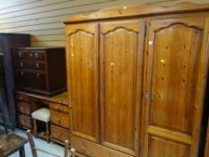 HONEY PINE TRIPLE WARDROBE with drawer base, together with a six drawer dressing table and stool