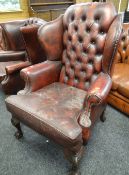 RED LEATHER CHESTERFIELD / CLUB TYPE WING-BACK ARM CHAIR on carved ball and claw supports