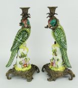 PAIR OF CONTINENTAL CERAMIC & GILT METAL CANDLESTICKS in the form of exotic birds holding branch