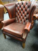 BUTTONED BACK RED LEATHER CHESTERFIELD / CLUB TYPE WING-BACK ARM CHAIR on reeded supports