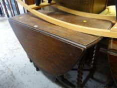 A CIRCULAR OAK DROP LEAF GATE LEGGED DINING TABLE, together with two wheel back arm chairs