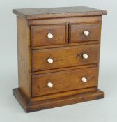 VICTORIAN MINIATURE CHEST of two long and two short drawers with believed bone turned handles, 30cms