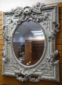 IMPOSING REPRODUCTION PAINTED FRAME OVAL-PANEL MIRROR with bevel glass, applied flowers and