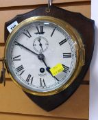 BRASS PORTHOLE STYLE WALL CLOCK mounted on a wooden shield back by Smiths Astral