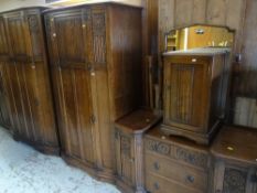 GOOD VINTAGE CROWN BEDROOM SUITE with carved Gothic and linen-fold decoration, comprising two drawer