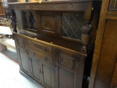 VINTAGE OAK OLD CHARM STYLE COURT CUPBOARD with carved decoration and centre cupboard flanked by