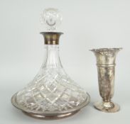 CUT GLASS SHIP'S DECANTER with silver collar raised on silver and turned wooden stand, mixed