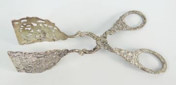 WHITE METAL PIERCED SCROLL & FOLIATE DECORATED TONGS believed silver