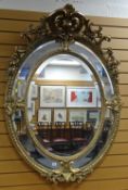 IMPRESSIVE REPRODUCTION ROCOCO STYLE OVAL WALL MIRROR with elaborate floral and scroll work finial
