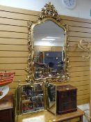 REPRODUCTION ROCOCO-STYLE FLORAL GILT FRAMED MIRROR and a gilt metal three pane toilet mirror