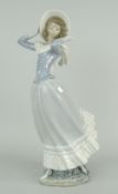 LLADRO PORCELAIN FIGURE OF A LADY struggling to keep her hat in a gust