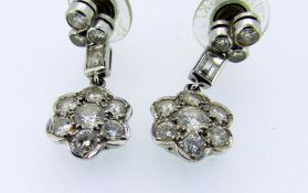 PAIR OF 18CT WHITE GOLD DIAMOND DROP EAR RINGS, the seven stone flower head drops suspended by