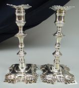 PAIR OF GEORGE II CAST SILVER CANDLESTICK HOLDERS with decorative bases and knopped stems, removable