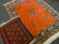 MAINLY RED GROUND WOOLEN RUG with patterned border, 240 x 180cms, together with a small geometric