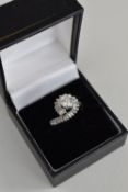 18CT WHITE GOLD DIAMOND RING having twist shank diamond setting, the central round brilliant cut
