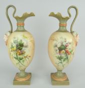 PAIR OF ROYAL WORCESTER OVOID PEDESTAL EWERS having loops handles terminating in mask mounts,