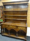 20TH CENTURY OAK WELSH DRESSER having an open base with arched frieze, three drawers and open