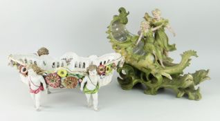 AUSTRIAN PORCELAIN FIGURAL FLOWER BASKET in the form of two figures straddling a sea-shell over a