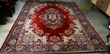 LARGE MAINLY RED & BLUE GROUND PERSIAN WOOLEN RUG with floral centre decoration and border, 325 x