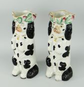PAIR OF STAFFORDSHIRE BEGGING SPANIEL SPILL HOLDERS with loop handles, black and white glaze, 19th