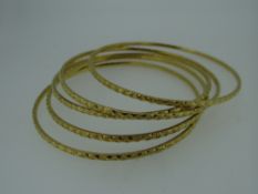 FIVE YELLOW METAL INDIAN DOWRY BANGLES (tested as high carat approximately 22ct gold), 56.8 grams (