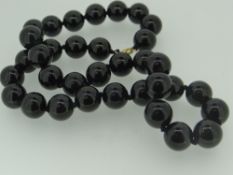 STRING OF BELIEVED HEMATITE BEADS with 9ct gold clasp