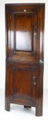 ANTIQUE STANDING TWO STAGE CORNER BLIND-CUPBOARD the top section with panelled door in elm, turned