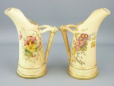 ROYAL WORCESTER - a pair of blush horn shaped jugs with floral decoration and horn handles, 1907,