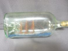 A THREE MASTED SHIP IN A BOTTLE, 29cms height