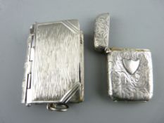 TWO VESTAS, one bright cut silver with scroll decoration and the other plated in the form of a book