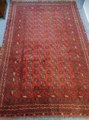 ANTIQUE RUG red and ground with tasselled ends, 165 x 204cms