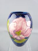 MOORCROFT MAGNOLIA BALUSTER VASE on a deep blue ground, 13.5cms H