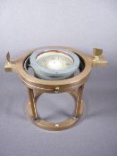 A GIMBAL COMPASS ON A BRASS STAND