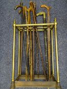 VINTAGE BRASS & CAST IRON EIGHT SECTION STICK STAND and a quantity of walking sticks and canes