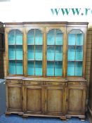 EARLY 20TH CENTURY REPRODUCTION WALNUT BREAKFRONT CABINET BOOKCASE having four upper glazed doors