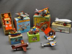 VINTAGE TYPE CLOCKWORK TIN PLATE TOYS (9) including aeroplanes, a Los Angeles Zeppelin and a chief