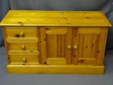 REPRODUCTION PINE SIDEBOARD with three end drawers and twin cupboard doors on a plinth base, 67cms