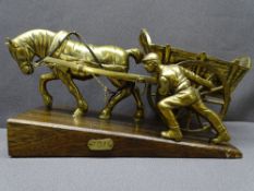 BRASS ORNAMENT ON WOODEN PLINTH entitled 'Toil of horse pulling a cart with workmen assisting',