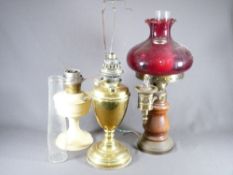 THREE VINTAGE OIL LAMPS including Cranberry glass shade