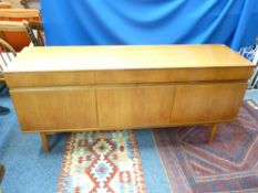 TEAK MID-CENTURY LONG SIDEBOARD having three frieze drawers and three cupboard doors, 75.5cms H,